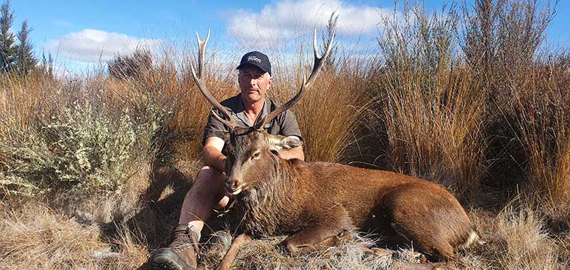 Hunter with Sika Deer in New Zealand
